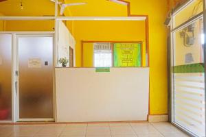 una habitación vacía con una pared amarilla y una puerta en OYO 91433 Hotel Sari Jeneponto en Jeneponto