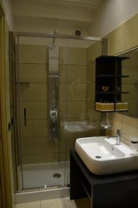 a bathroom with a glass shower and a sink at Art & Jazz Hotel in Catania