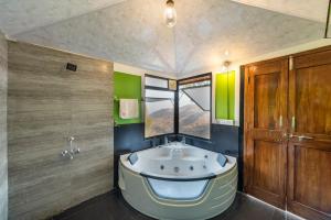 a bathroom with a large tub in the middle of the room at SaffronStays Verandah by the Valley, Panchgani - luxury villa and treehouse with beautiful valley and lake views in Panchgani