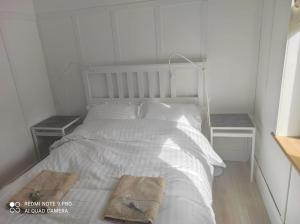 1 dormitorio con 1 cama blanca y 2 mesitas de noche en The Wild Farm Lodge, en Mullingar