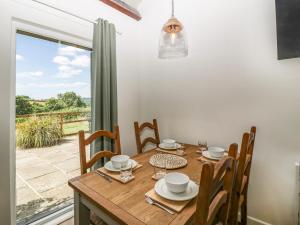 a dining room with a table and chairs and a window at The Old Kennels in Sidmouth