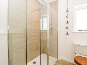 a glass shower in a bathroom with a toilet at The Old Kennels in Sidmouth