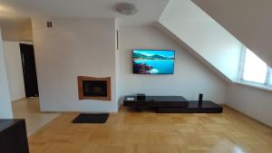 a living room with a couch and a tv on the wall at Apartament Prosta Kielce in Kielce