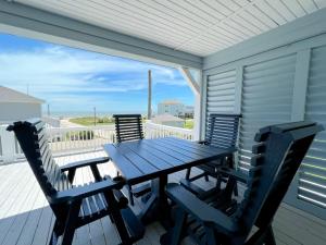 a table and chairs on a porch with a view of the ocean at Ohana home in Crystal Beach