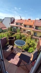 un patio con 2 sillas y una mesa en el balcón en Apartament Prosta Kielce, en Kielce