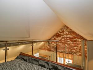 a bedroom with a bed and a brick wall at The Studio in Hungerford