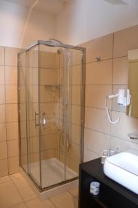 a glass shower in a bathroom with a sink at Art & Jazz Hotel in Catania