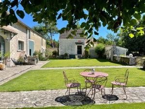 a pink table and chairs in a yard at La Pierre Levée in Montigny-sur-Loing