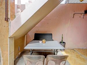 einen Tisch und Stühle in einem Zimmer mit Treppe in der Unterkunft OYO 91428 Duta Stay in Tanjung Pinang 