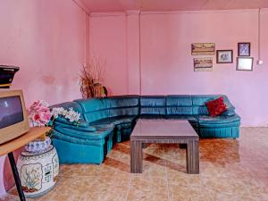 OYO 91428 Duta Stay في تانجونغ بينانغ: غرفة معيشة مع أريكة زرقاء وطاولة