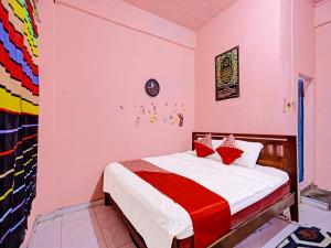OYO 91428 Duta Stay في تانجونغ بينانغ: غرفة نوم بسرير ذو شراشف بيضاء ومخدات حمراء