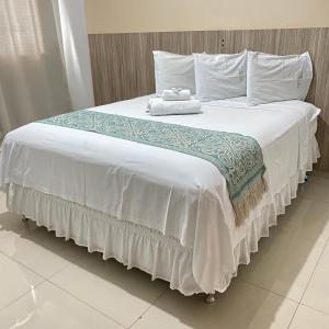 Hotel Rio Verde في Dianópolis: سرير كبير عليه شراشف بيضاء ومناشف