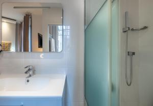 a bathroom with a sink and a shower at Makom Pereire in Paris