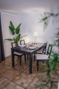 een zwarte eettafel met twee stoelen en een plant bij Ferienwohnung Heidis Heidehaus in Schneverdingen
