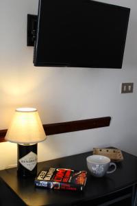 une table avec une lampe, des livres et une tasse dans l'établissement Casa Vacanze San Gregorio Magno, à San Gregorio Magno