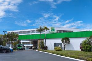 a building with a green roof and a parking lot at Holiday Inn St. Petersburg N - Clearwater, an IHG Hotel in Clearwater