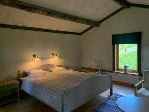 a bedroom with a white bed and a window at Bogärdan, cozy cabin by the Luleå River in Harads