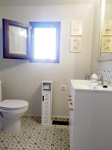 a bathroom with a toilet and a sink at Casa Rural El Olivo in Aracena