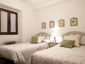 dos camas sentadas una al lado de la otra en un dormitorio en Casa rural El Olivo, en Aracena