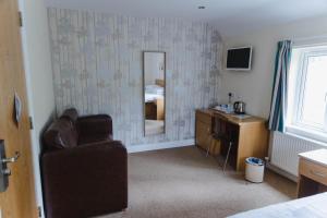 a bedroom with a chair and a desk and a mirror at Cliff College in Curbar