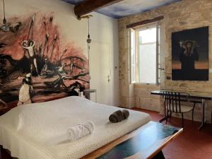 Habitación con cama y pintura en la pared en Le Regardeur, en Saint-Rémy-de-Provence