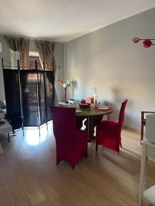 ein Esszimmer mit einem Tisch und roten Stühlen in der Unterkunft B&B Affaccio sul Vaticano in Rom