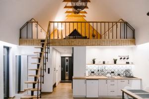 a kitchen with a loft conversion with a spiral staircase at Całoroczny Domek na Podlasiu PoWolność in Grodzisk
