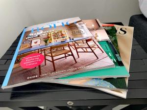 una pila di riviste seduta sopra un tavolo di Room in a Danish cottage with garden view, 10 min to CPH a Gentofte