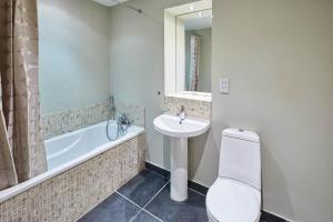 a bathroom with a toilet and a sink and a tub at Host & Stay - Three Bays in Scarborough