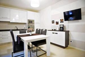 a kitchen with a white table and black chairs at VENTUNO - Modern Apartment - Country & Lake in Lovere