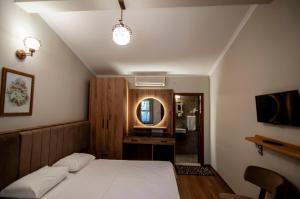 a bedroom with a white bed and a mirror at Fener Motel in Şile