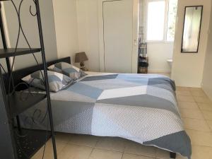 um quarto com uma cama com um edredão azul e branco em chambres d'hotes Labatut em Labatut