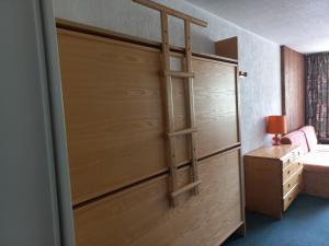 - un placard avec une porte en bois, un lit et une lampe dans l'établissement Studio Tignes, 1 pièce, 4 personnes - FR-1-449-58, à Tignes