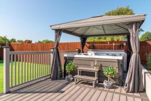 einen Pavillon mit einem Whirlpool auf einer Terrasse in der Unterkunft Four Oaks House in Carlisle