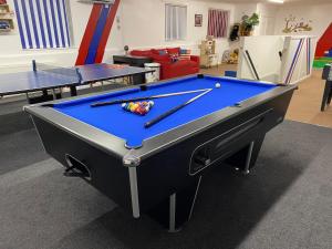 a pool table in a room with two ping pong tables at Four Oaks House in Carlisle