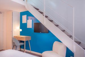 Habitación con cama, escritorio y escalera. en Makom Pereire en París
