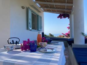 a table with plates and bowls on it with a view at Casa Nica in Ustica