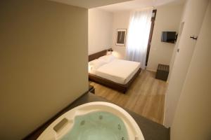 een badkamer met een bad en een slaapkamer met een bed bij Hotel Orientale in Brindisi