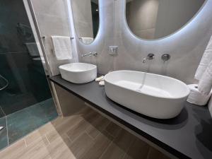 La salle de bains est pourvue d'un lavabo et d'un miroir. dans l'établissement Pegasus Hotel, à Sassari