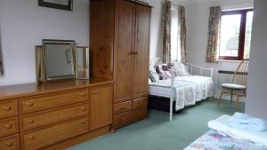 Dormitorio con tocador con espejo y cama en Bramley Cottage Holidays, en Chichester