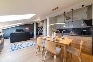 cocina y sala de estar con mesa de madera y sillas en Portal House Apartments en Cracovia