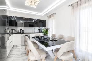 a white kitchen with a dining table and chairs at Boheme Villa in Zakynthos