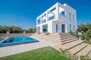 a white house with a swimming pool and stairs at Boheme Villa in Zakynthos