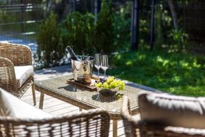 a table with wine glasses and a bowl of grapes at Luxury apartment DOLCE VITA in Palanga