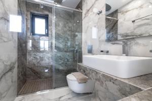 ein Bad mit einer Dusche, einem Waschbecken und einem WC in der Unterkunft Boheme Villa in Zakynthos