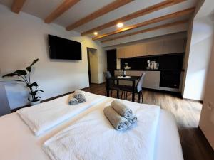 una camera con 2 letti bianchi e un tavolo di Apartments Hlapi with SPA a Kobarid