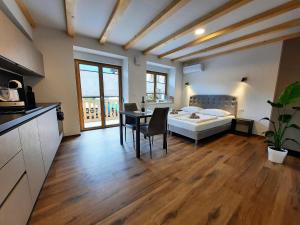 a bedroom with a bed and a table and a kitchen at Apartments Hlapi with SPA in Kobarid