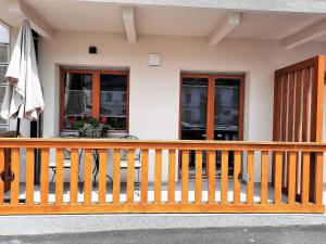 a house with a wooden railing and an umbrella at Apartments Hlapi with SPA in Kobarid