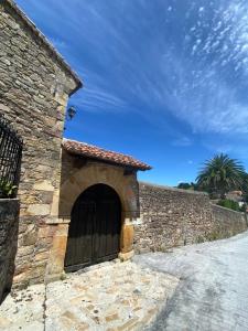 een stenen gebouw met een grote houten deur bij Posada La Lomba in Hermosa