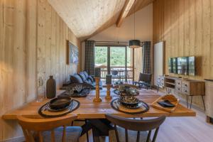 a dining room with a wooden table and chairs at TERRESENS - Cristal Lodge in Saint-Chaffrey